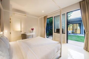 a modern and bright bedroom with large windows and a view of the garden