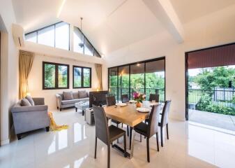 Spacious living and dining area with high ceiling and large windows