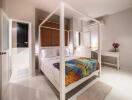 Modern bedroom with a four-poster bed and colorful bedspread