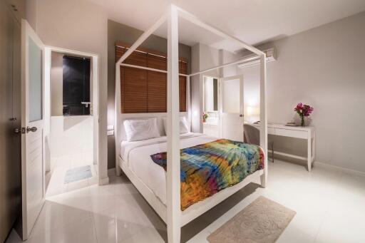 Modern bedroom with a four-poster bed and colorful bedspread