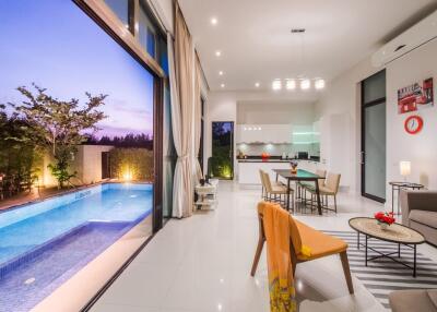 Modern living area with open kitchen and pool view