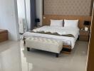 Spacious and modern bedroom with a large bed, bedside tables, an air conditioner, and a dressing table