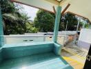 Covered outdoor patio with green tiles and view of driveway