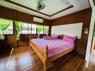 Cozy bedroom with wooden flooring and large windows