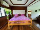 Spacious bedroom with wooden flooring and vibrant decor