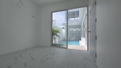 Room with sliding doors leading to a pool area