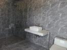 Spacious modern bathroom with tiled walls and floor, shower, sink, and toilet