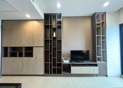 modern living room with built-in shelving and mounted TV