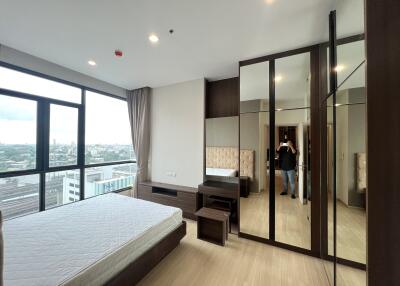 Modern bedroom with large window and mirrored wardrobes