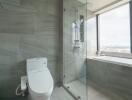 Modern bathroom with shower, toilet, and window