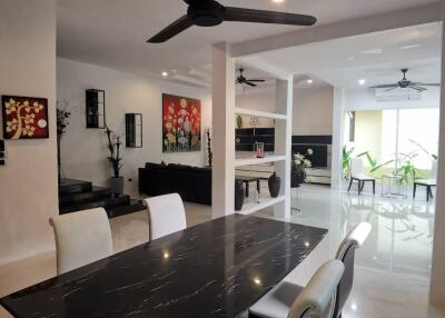 Modern dining area with black dining table and white chairs