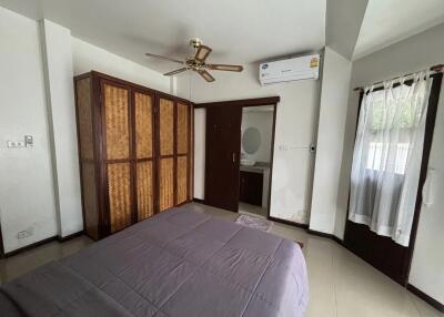 Bedroom with bed, wardrobe, ceiling fan, and air conditioner