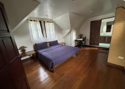 Spacious bedroom with wooden flooring and desk space