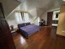 Spacious bedroom with wooden flooring and desk space