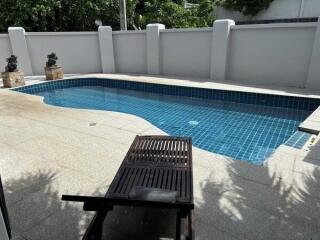 Outdoor swimming pool area with lounge chair