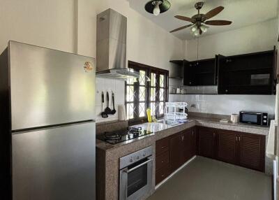 Modern kitchen with stainless steel appliances and overhead fan