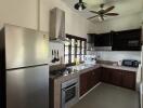 Modern kitchen with stainless steel appliances and overhead fan