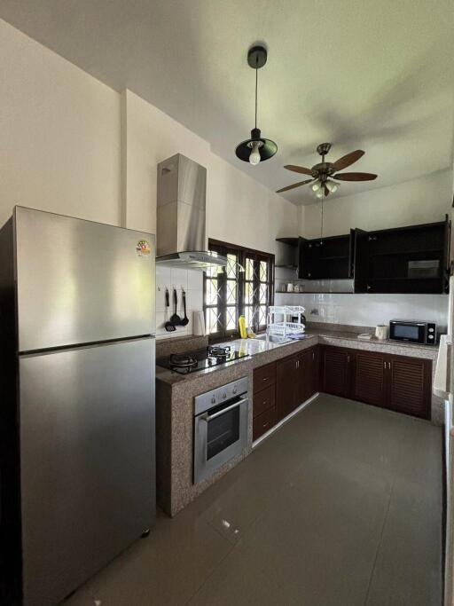 Modern kitchen with stainless steel appliances and overhead fan