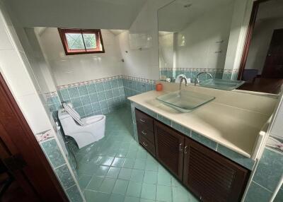 Modern bathroom with tiled floor, glass sink, and large mirror