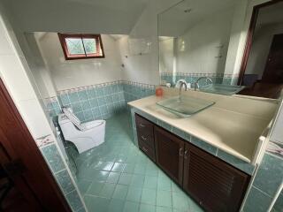 Modern bathroom with tiled floor, glass sink, and large mirror