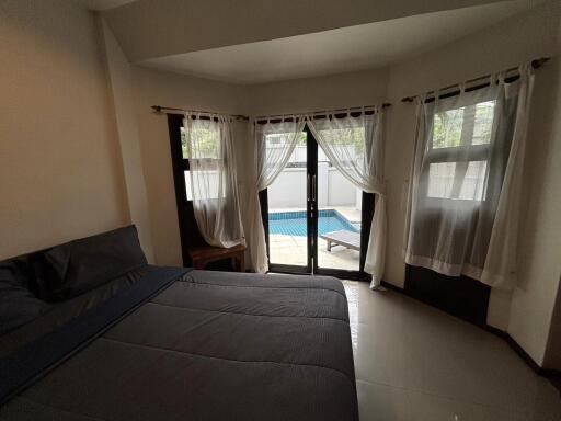 A bedroom with a view of a private pool