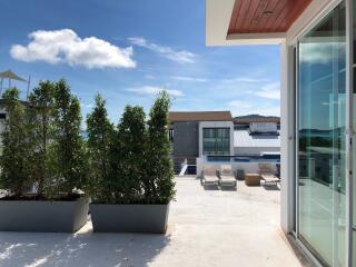 Rooftop patio with plants and sun loungers