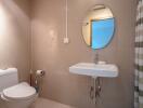 Modern bathroom with circular mirror and basin sink