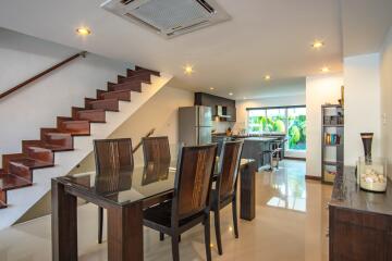 Modern open-plan dining area with adjacent kitchen