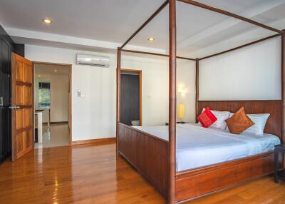 Spacious bedroom with wooden flooring and a four-poster bed