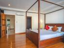 Spacious bedroom with wooden flooring and a four-poster bed