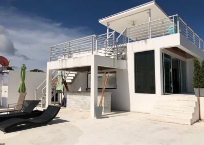 Modern two-story house with rooftop terrace and outdoor seating