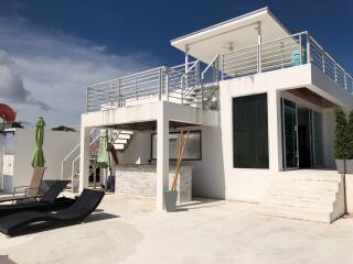 Modern two-story house with rooftop terrace and outdoor seating