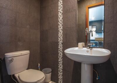 Modern bathroom with dark tiles and a pedestal sink