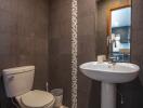 Modern bathroom with dark tiles and a pedestal sink