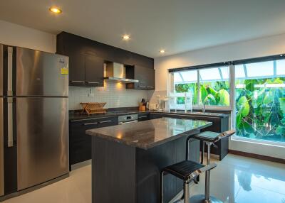 Modern kitchen with island, stainless steel appliances, and large window