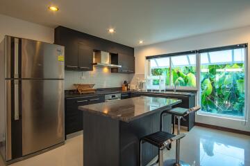 Modern kitchen with island, stainless steel appliances, and large window