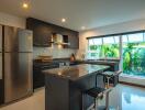 Modern kitchen with island, stainless steel appliances, and large window