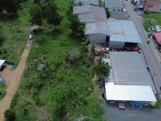 Aerial view of a property with large green yard and multiple buildings