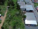 Aerial view of a property with large green yard and multiple buildings