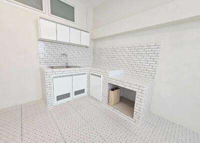 Minimalist white kitchen with tiled walls and floors