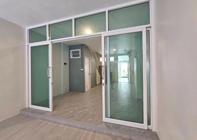 Entryway with glass sliding doors leading into a corridor