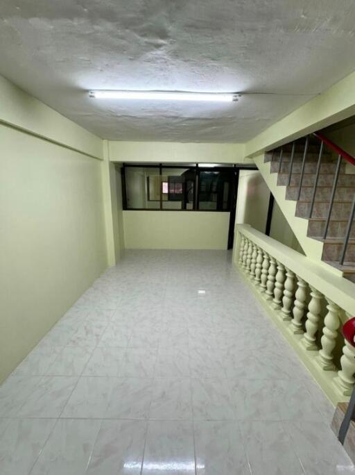 Spacious living area with tiled flooring and staircase