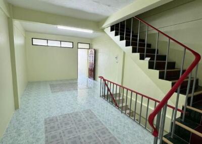 Spacious main living area with tiled flooring and stairwell