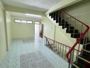 Spacious main living area with tiled flooring and stairwell