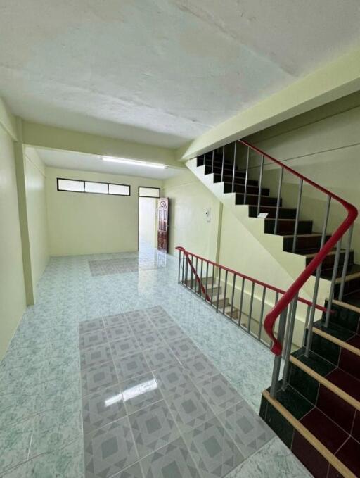 Spacious main living area with tiled flooring and stairwell