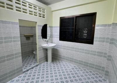Bathroom with sink, mirror, window, and tiled walls and floor