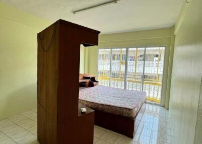 Spacious bedroom with large window and tiled floor