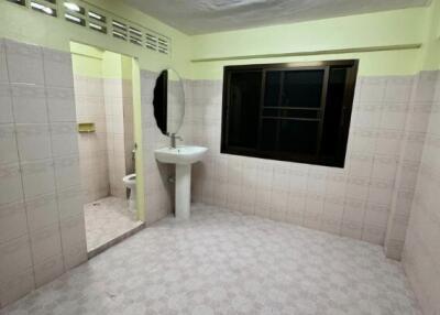 Unfurnished bathroom with a sink and a round mirror.