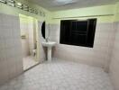 Unfurnished bathroom with a sink and a round mirror.