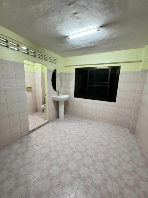 Unfurnished bathroom with a sink and a round mirror.